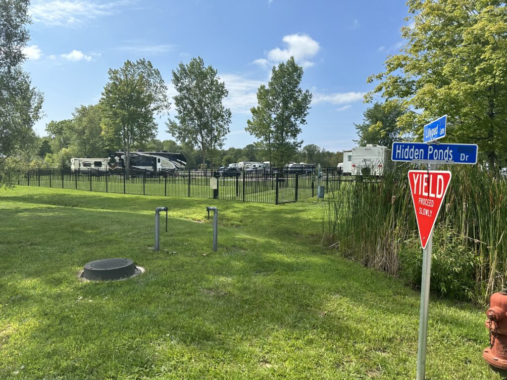 Full-hookup RV site surrounded by trees at Hidden Ponds RV Resort South Haven